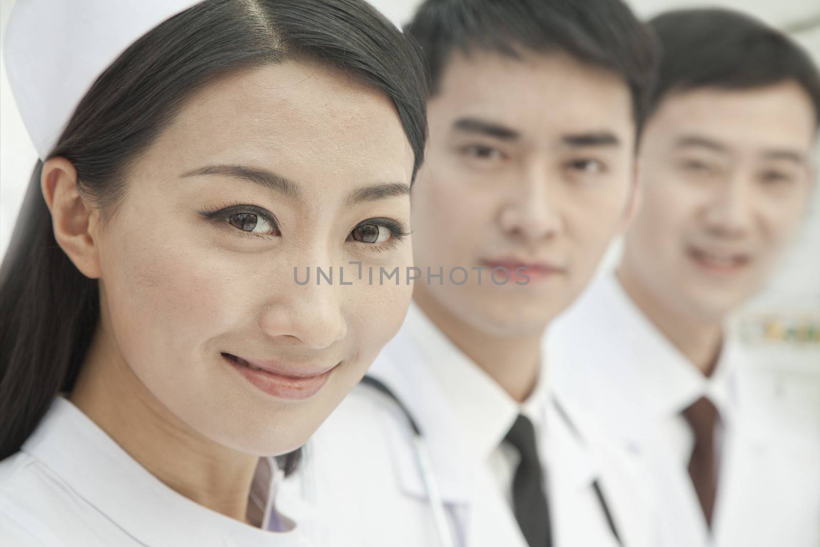Healthcare workers standing in a row, China, Close-up by XiXinXing