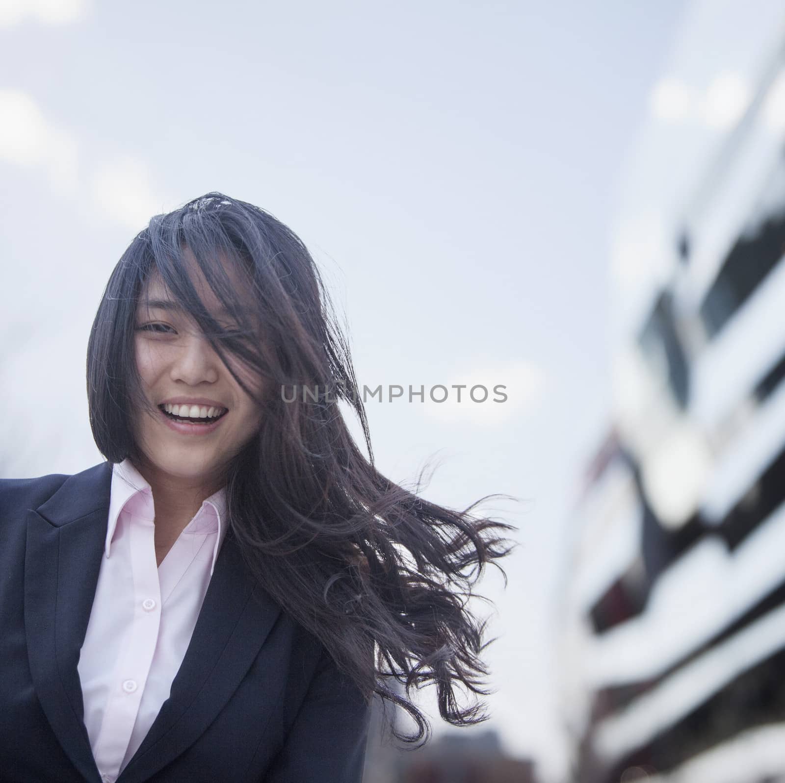 Young businesswoman smiling with hair blowing