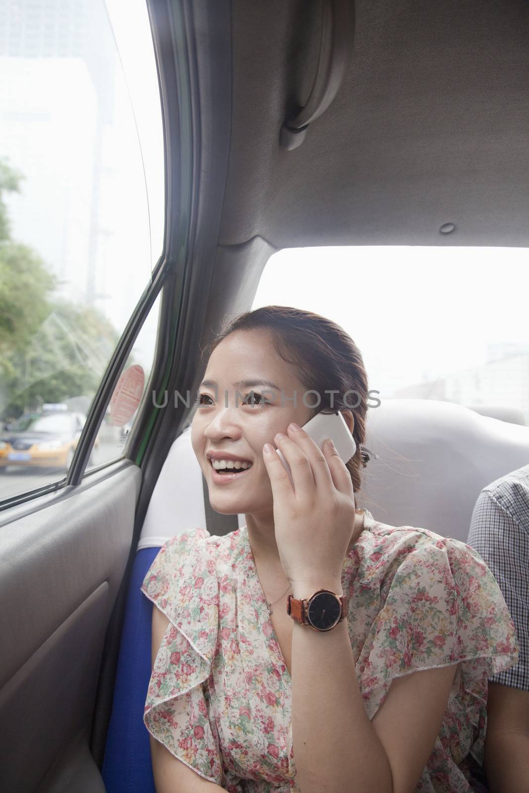 Young Woman With Cell Phone In Taxi by XiXinXing