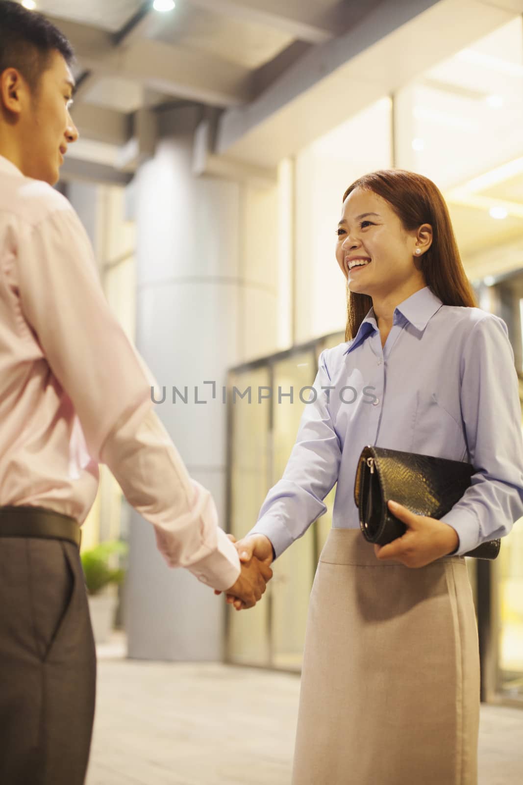 two business people handshaking outside the office 