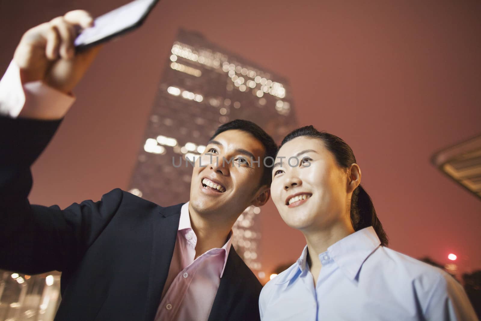 two business people smiling and taking a picture with the phone  by XiXinXing