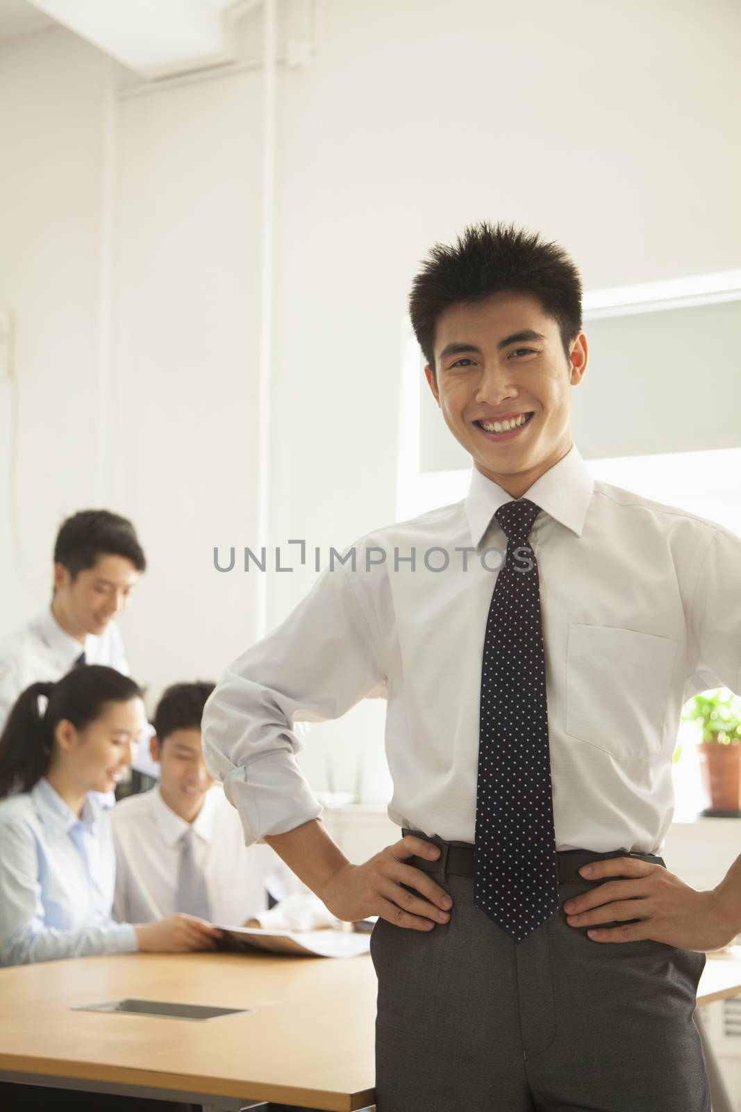Young man smiling in the office, portrait by XiXinXing
