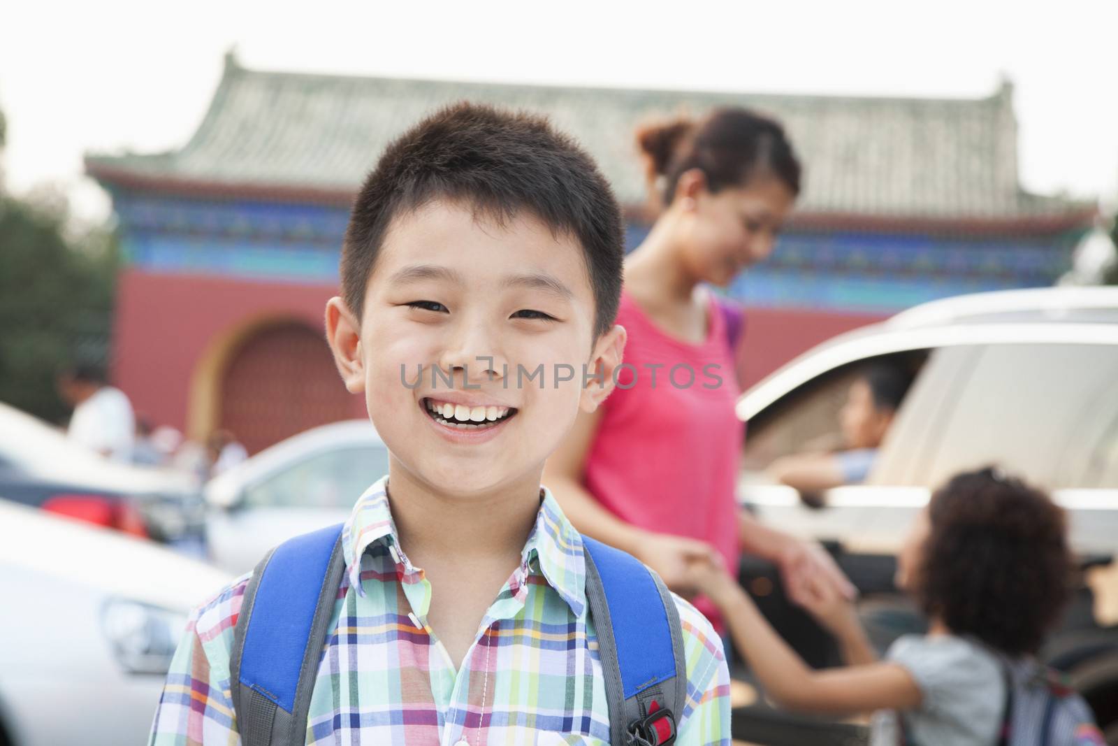 Portrait of boy with his family in the background