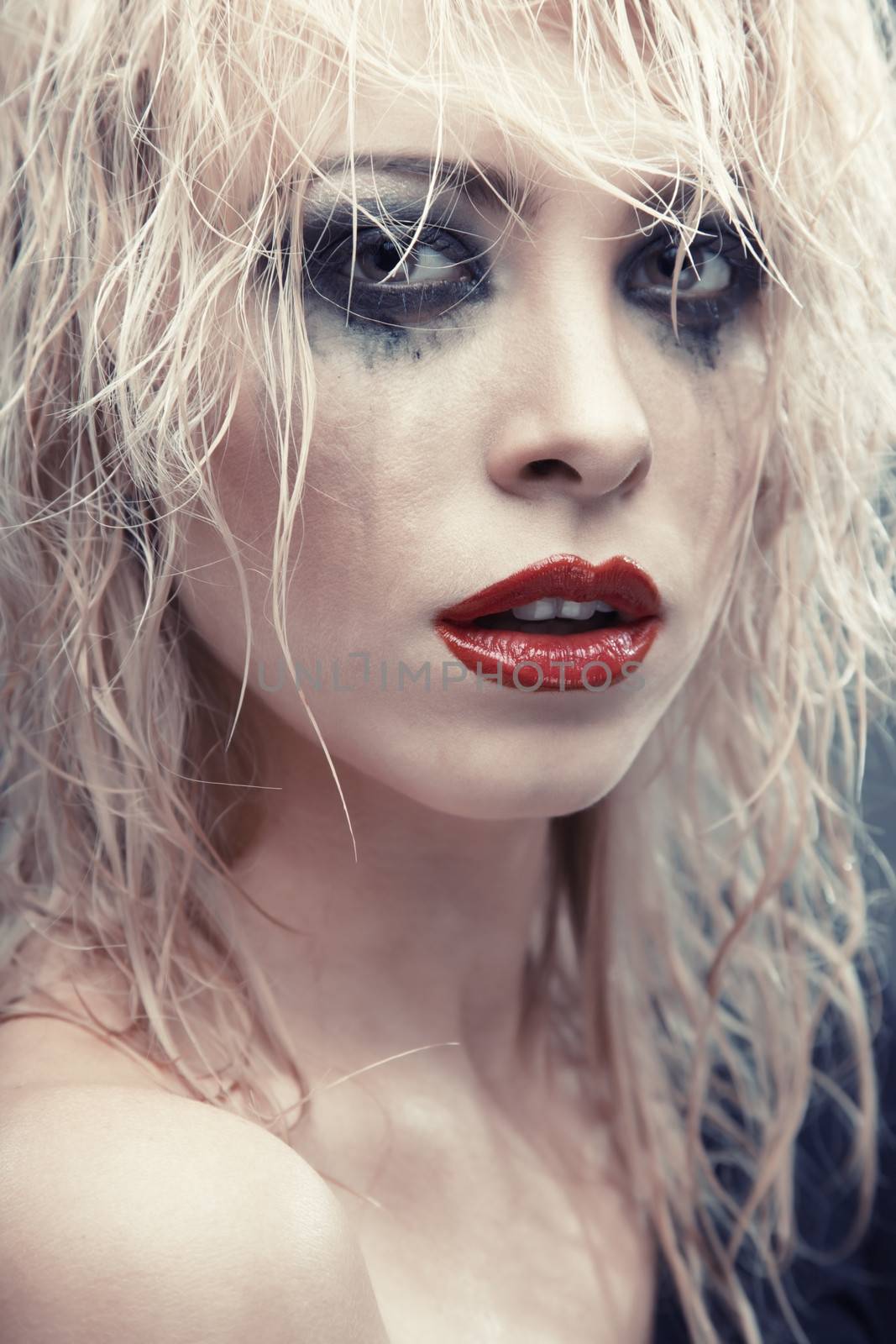 Blond lady with strange makeup. Vertical photo