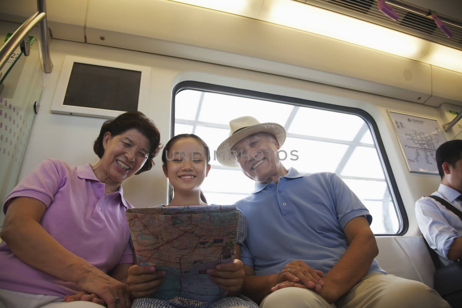 Granddaughter with grandparents sitting in the subway and looking at the map by XiXinXing