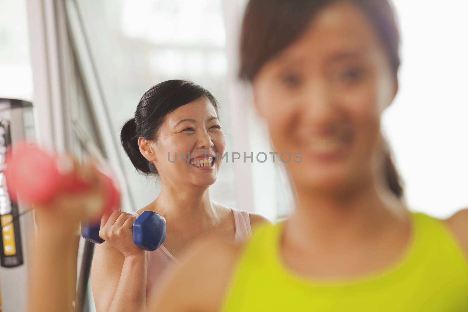 Mature women lifting weights in the gym 
