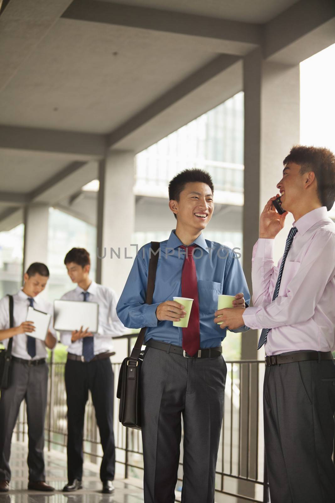 Group of young businessmen working and discussing outdoor by XiXinXing