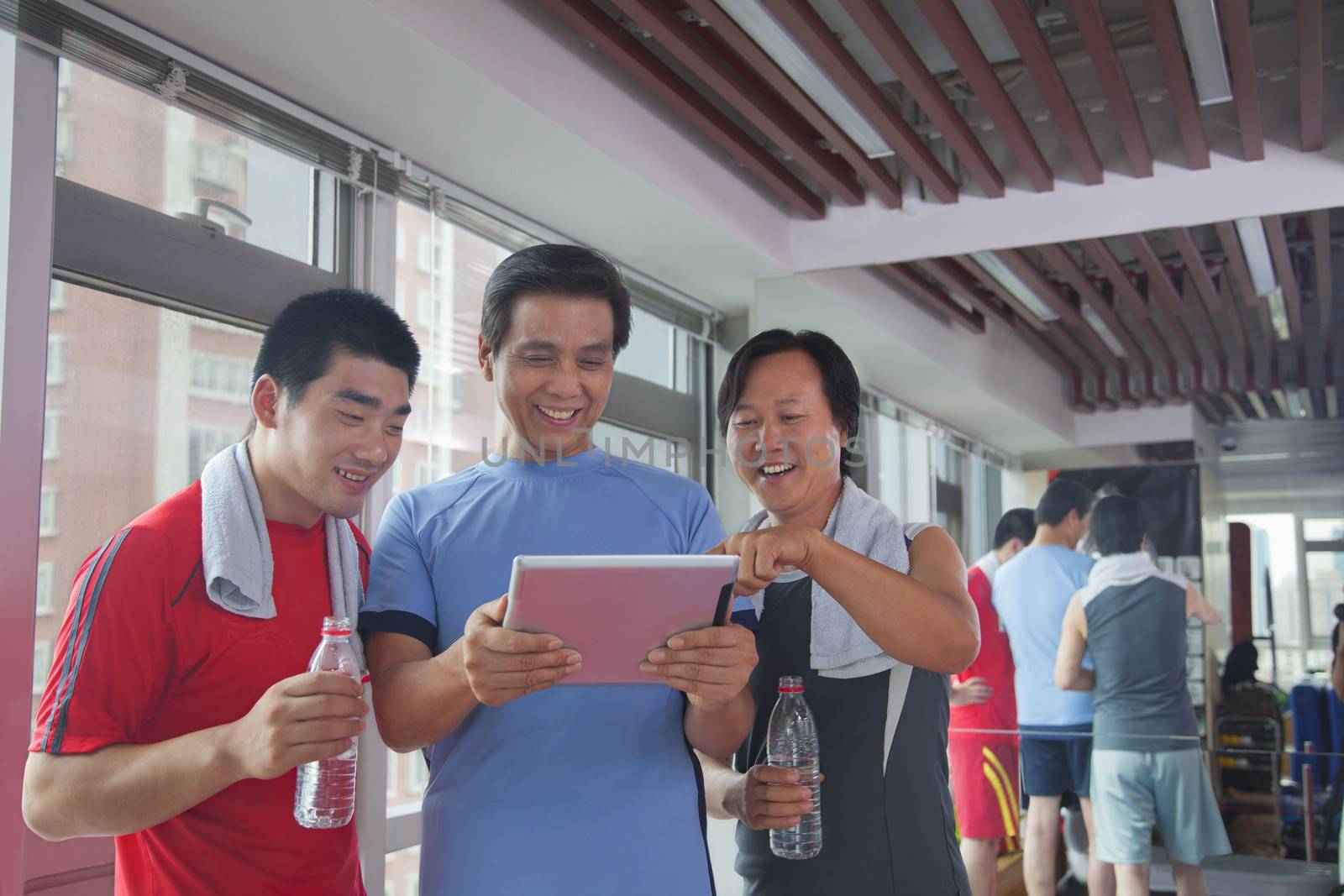 group of people looking at digital tablet in the gym  by XiXinXing