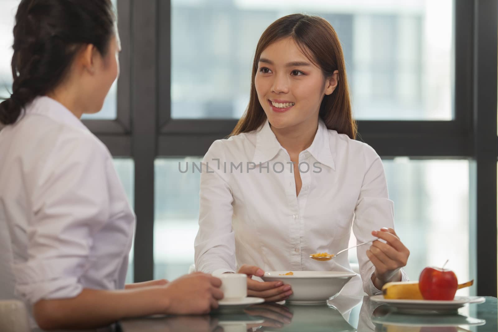 Businesswomen eating breakfast by XiXinXing