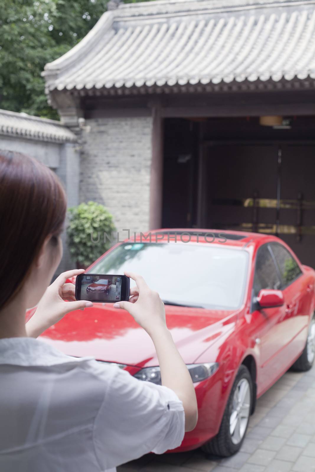 Young Woman Taking a Picture of Her Car by XiXinXing