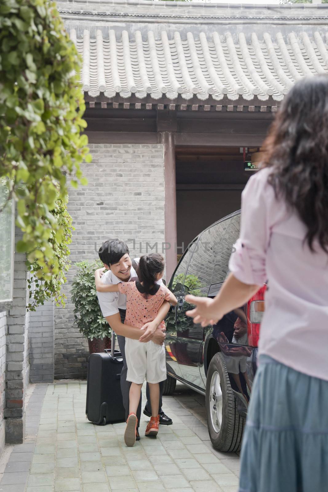 Businessman Hugging His Daughter After Coming Back from a Business Trip by XiXinXing