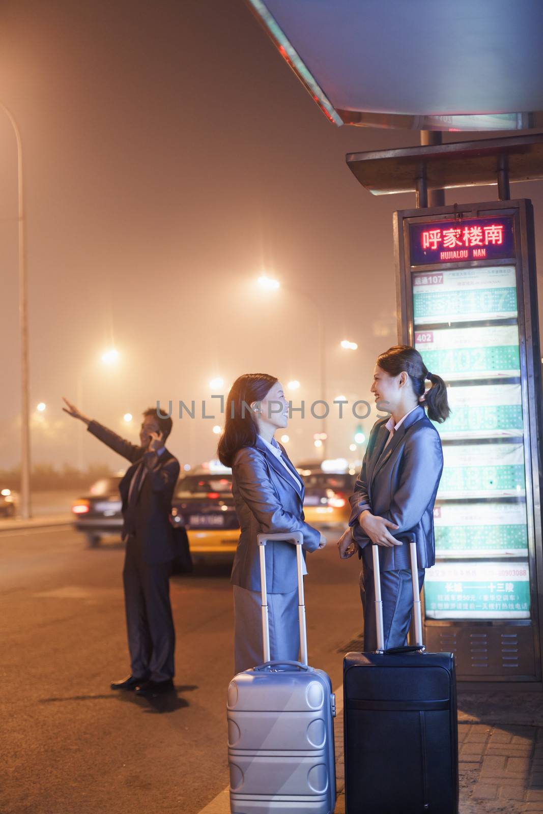 Young business people waiting for a taxi by XiXinXing
