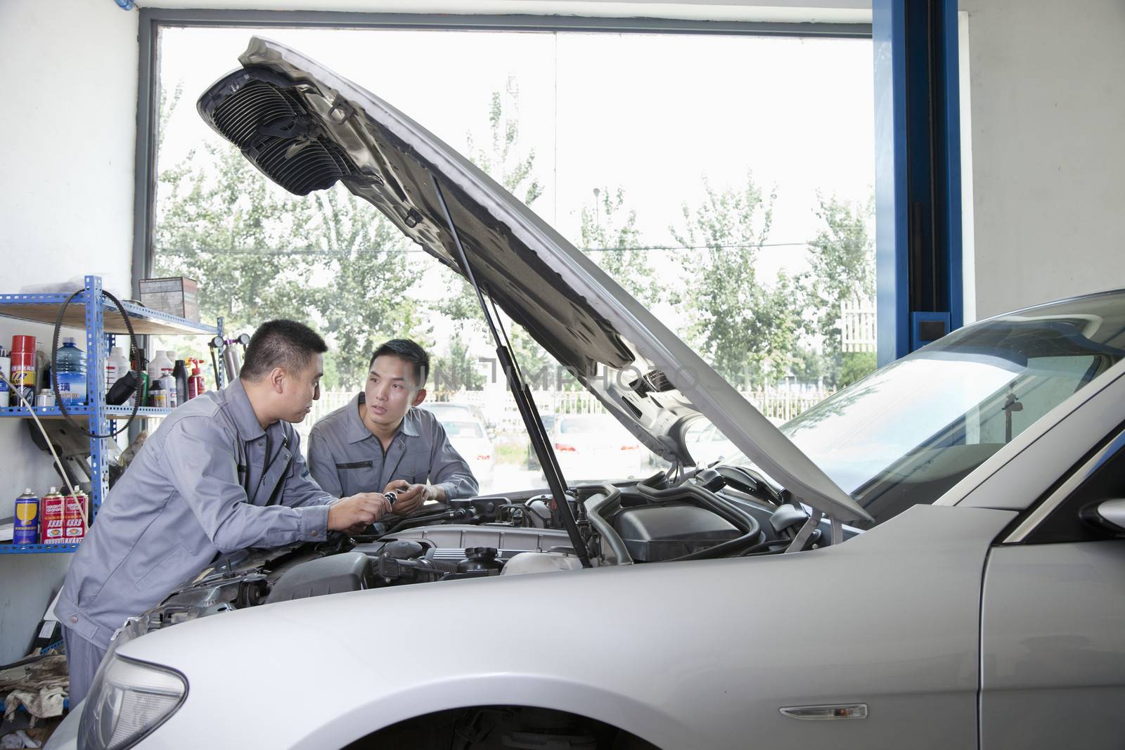 Two Garage Mechanics Working on Engine by XiXinXing