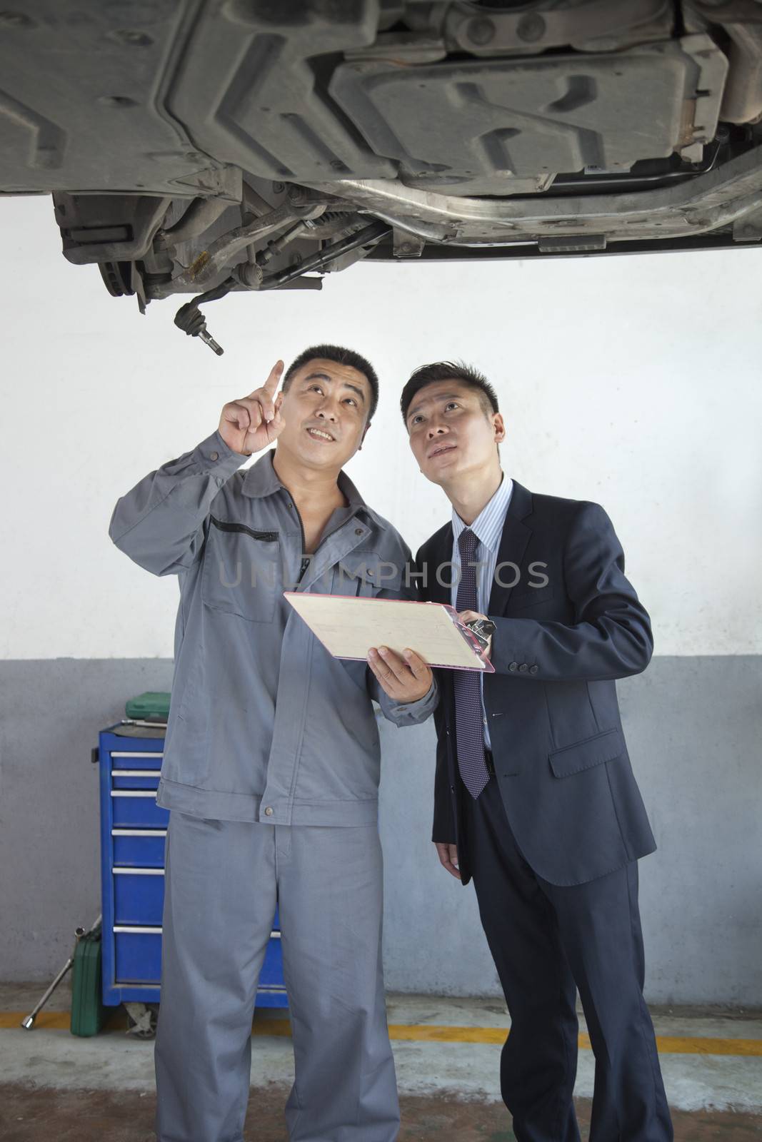 Mechanic Explaining to Businessman  by XiXinXing