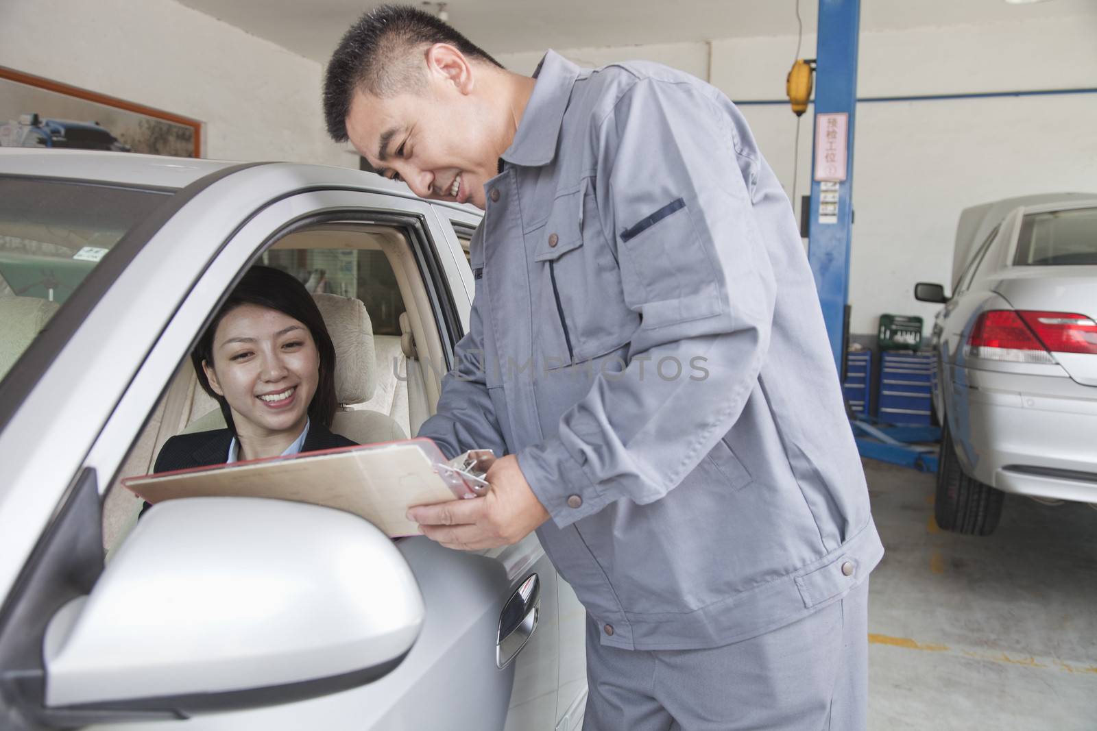 Mechanic Explaining to Businesswoman