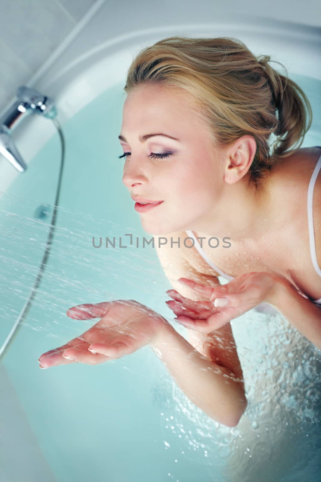 Smiling lady in the bathroom using shower