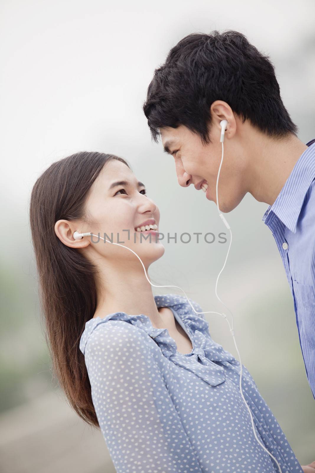 Young Couple Listening to Music Together by XiXinXing