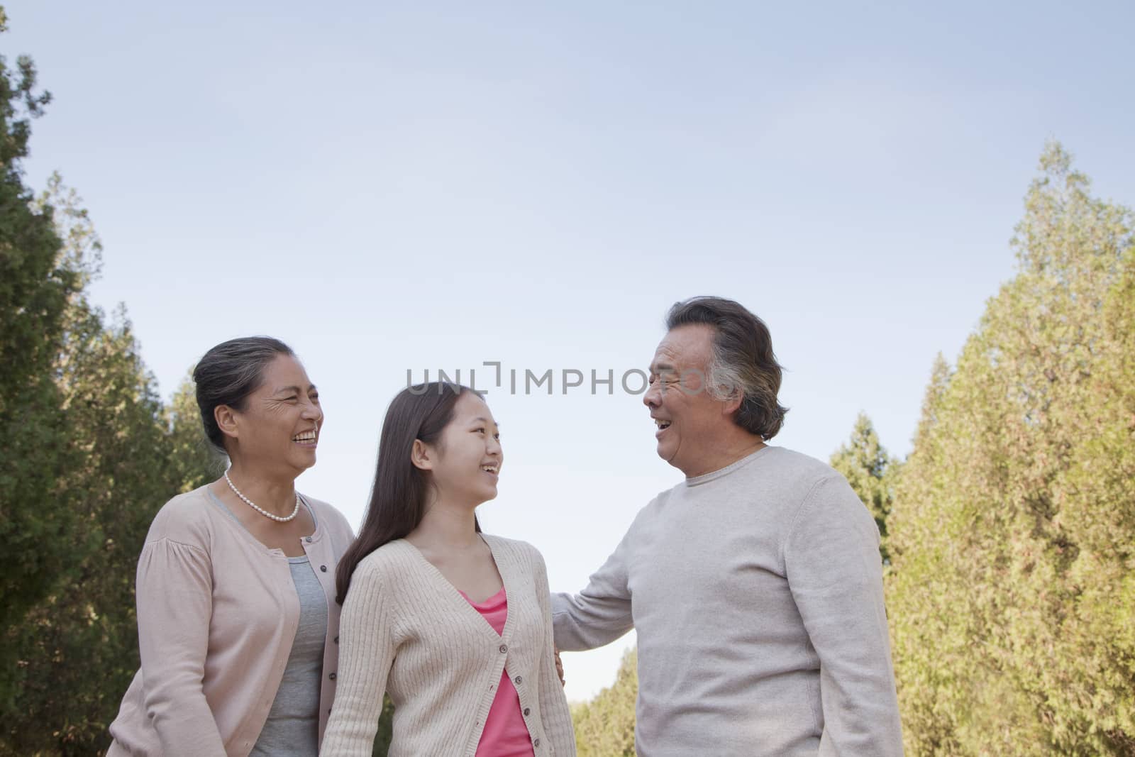 Granddaughter with grandparents walking in the park  by XiXinXing