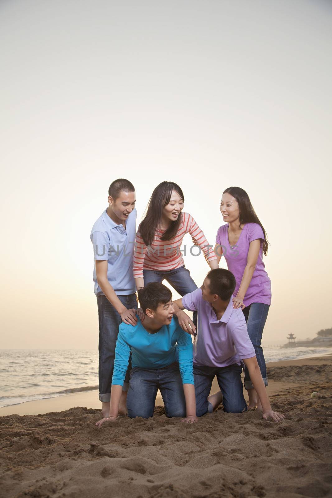Group of Friends Making Human Pyramid on the Beach by XiXinXing