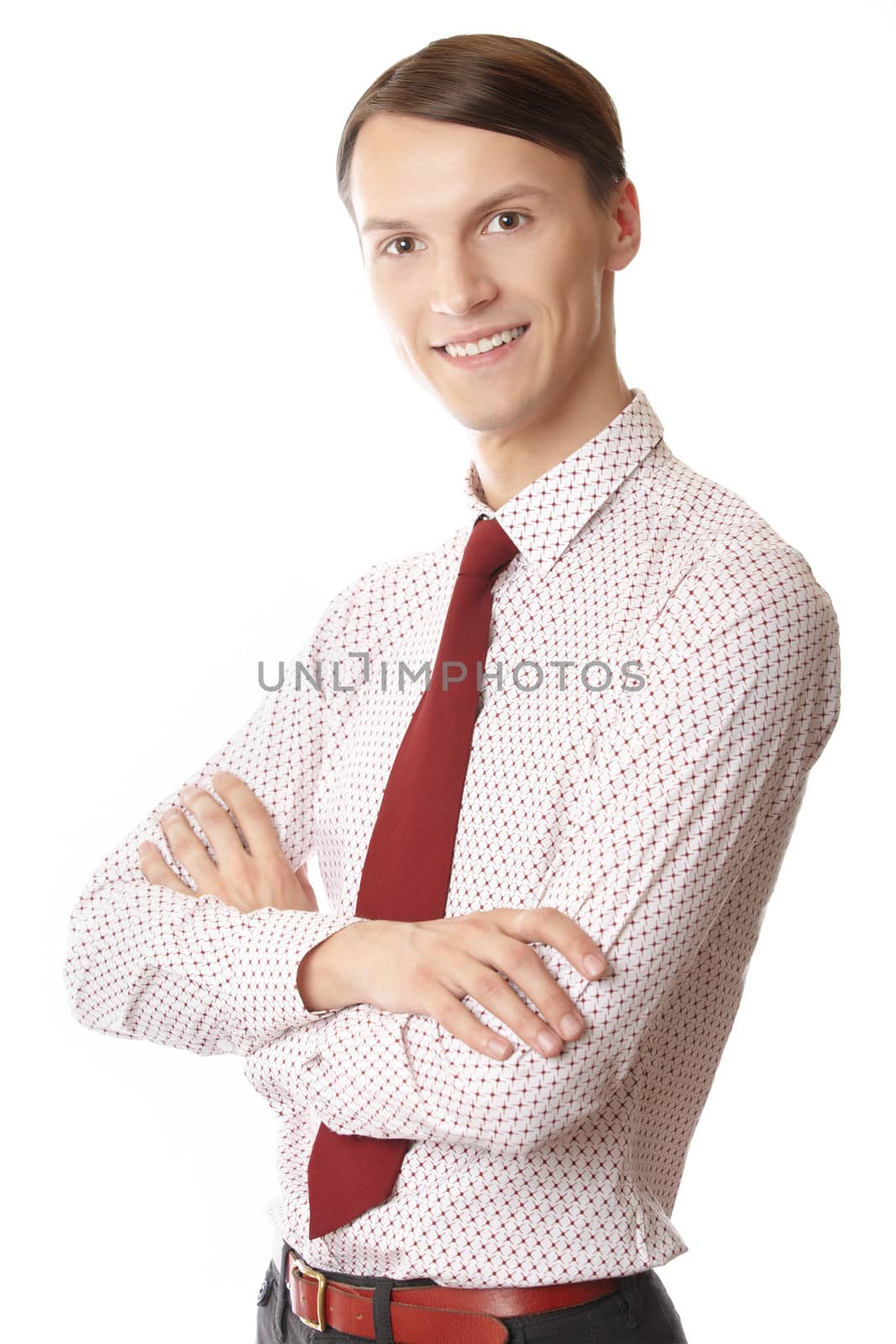 Young smiling businessman with arms crossed on a white background