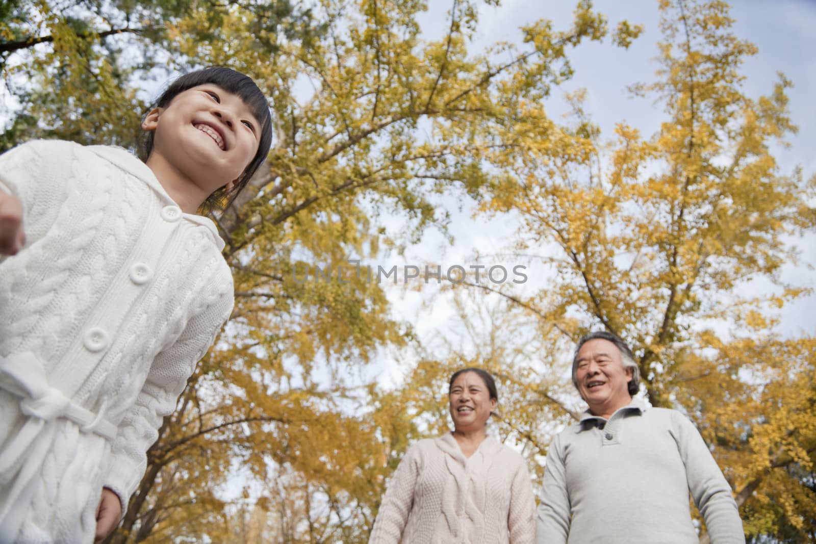 Grandparents and granddaughter in park by XiXinXing