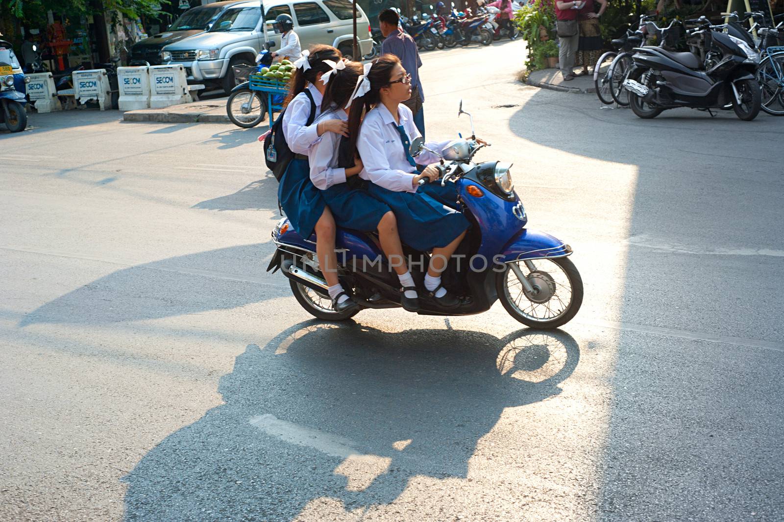 Chiang Mai, Thailand - Feb 27, 2013: Unidentified schoolgirls riding by motorbike in Chiang Mai, Thailand. Motorbike is the most popular and available transportation in South Asia.