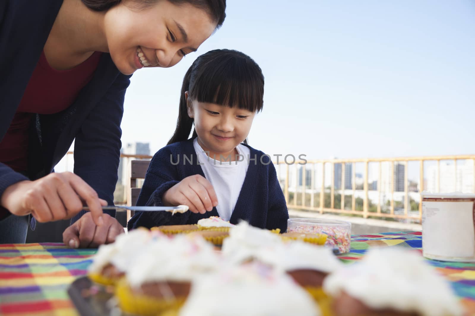 Mother and daughter decorating cupcakes by XiXinXing