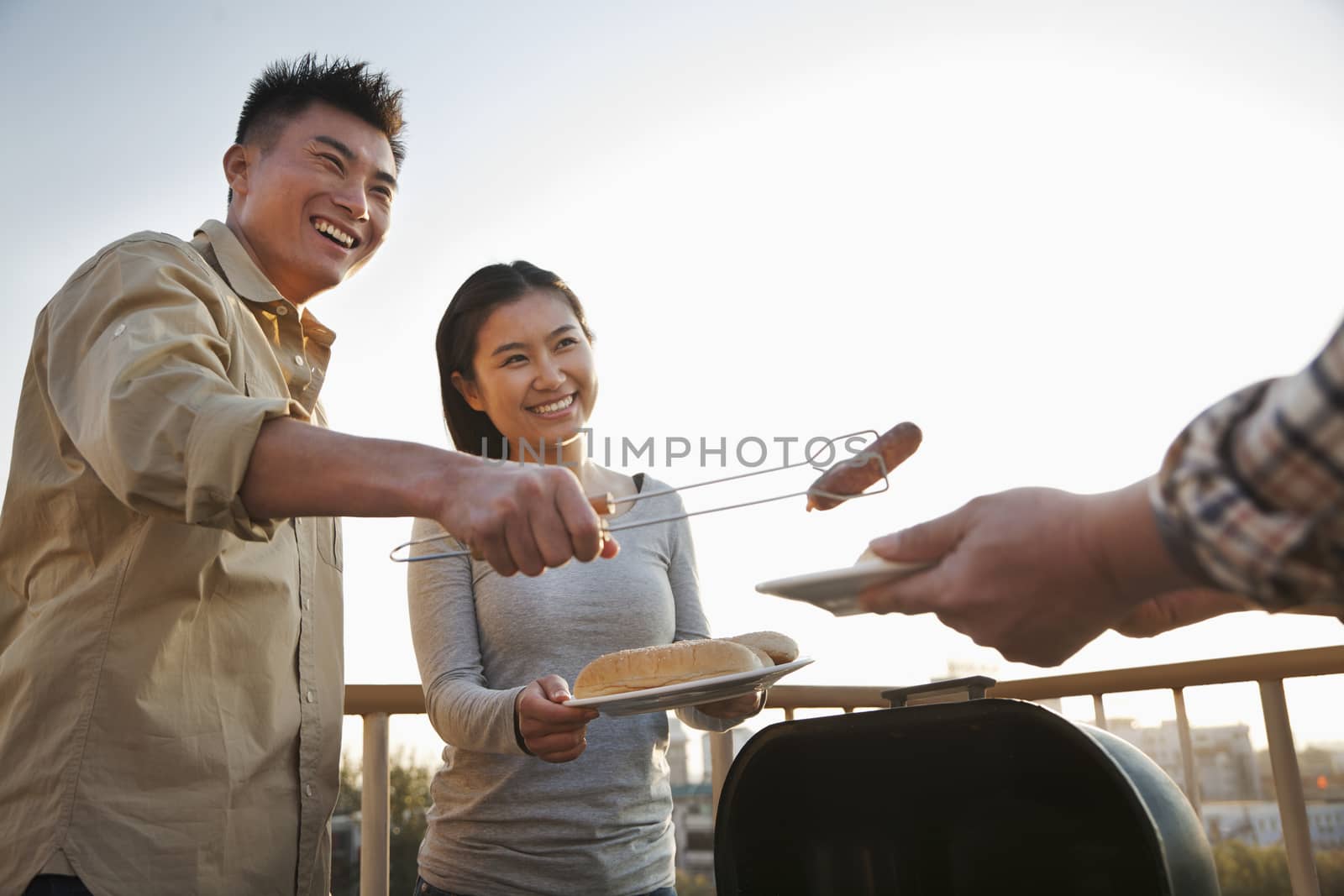 Son giving sausage to his father over the barbeque by XiXinXing