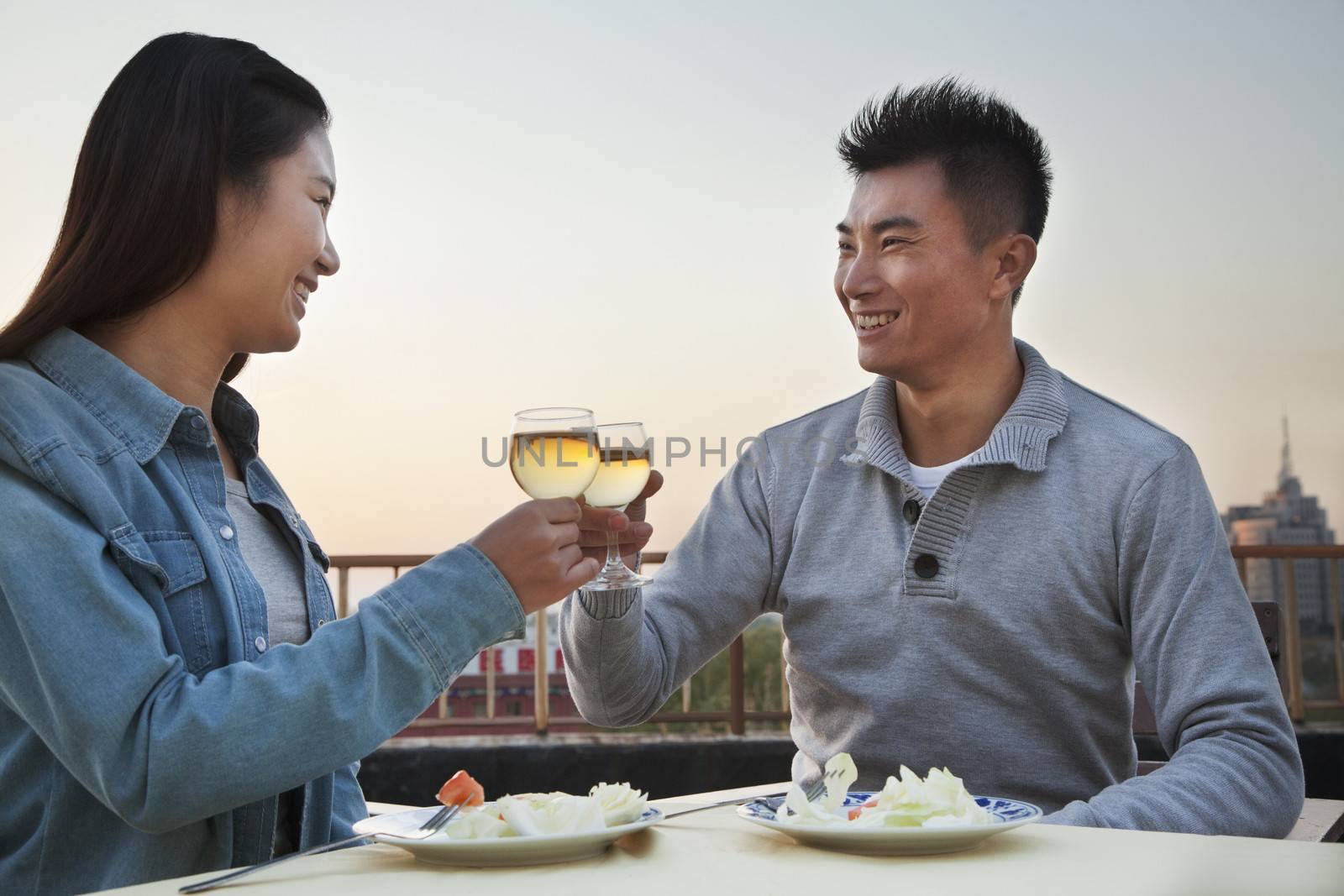 Young couple eating on the roof top, toast  by XiXinXing