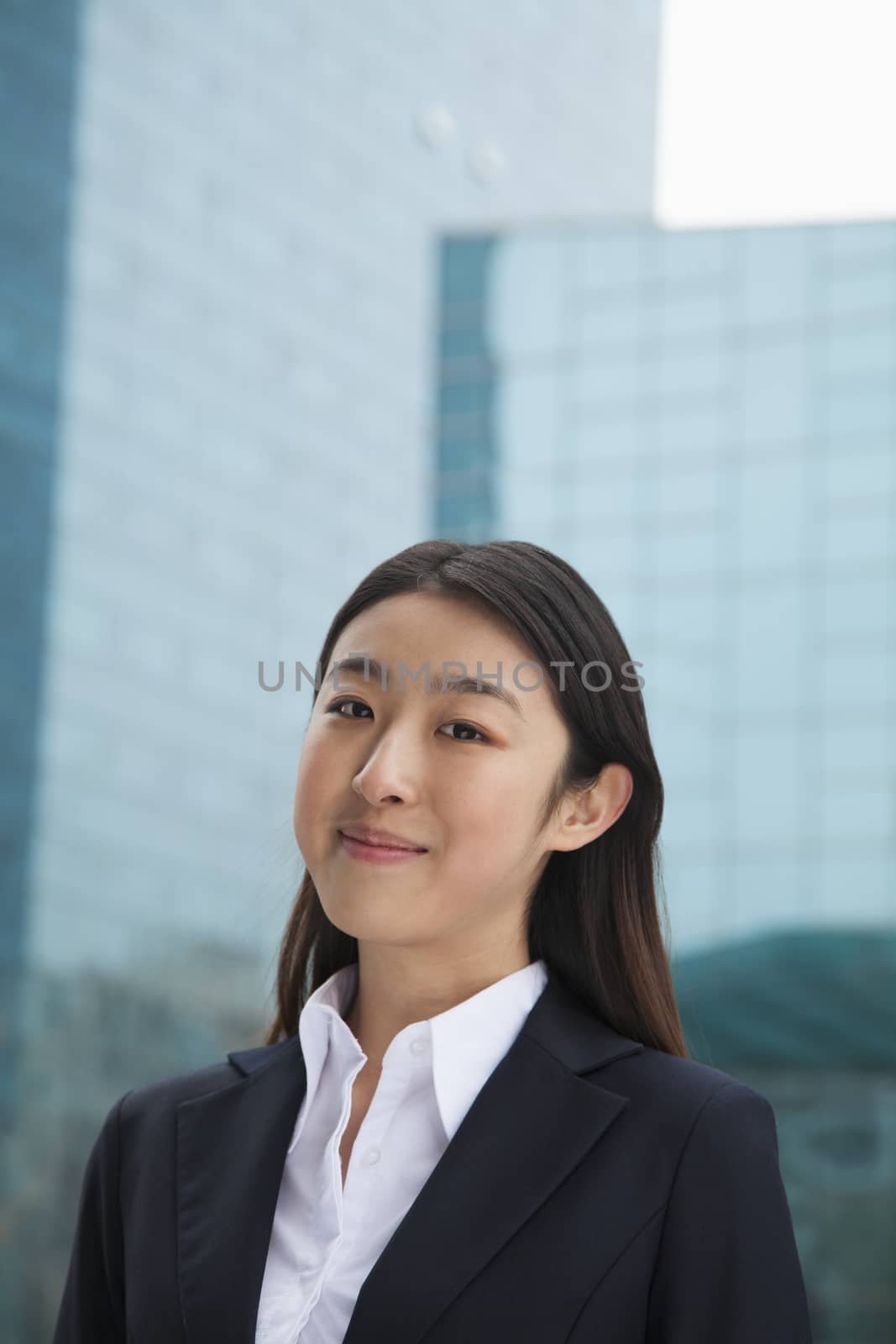 Portrait of young businesswoman outdoors among skyscrapers