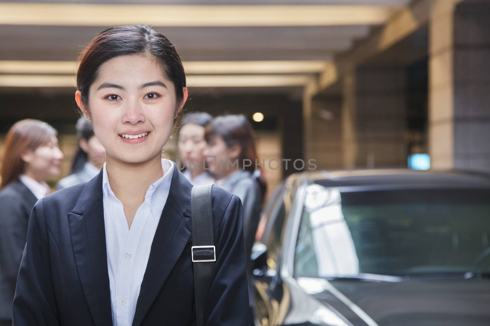 Portrait of Young businesswoman in parking garage  by XiXinXing
