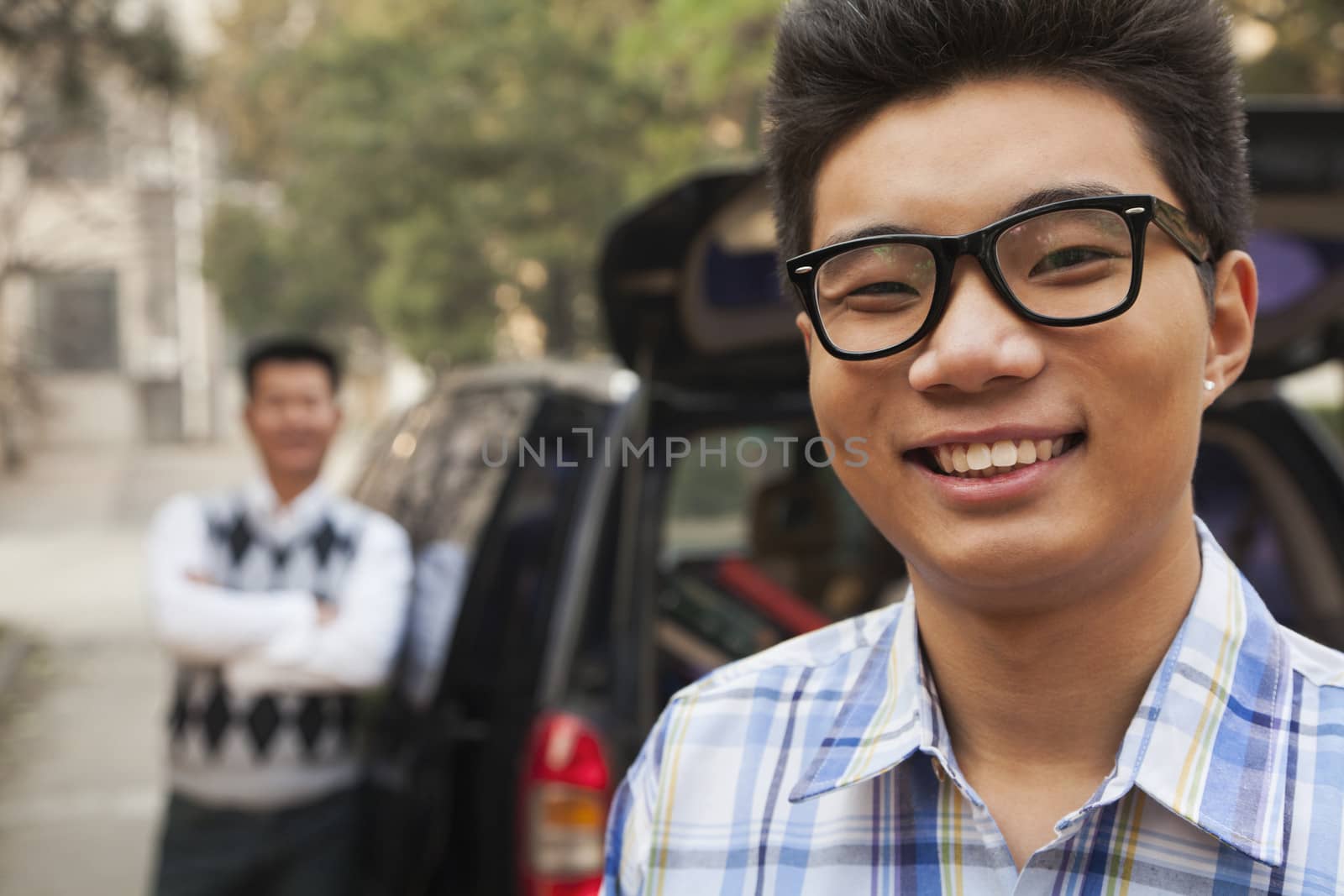 Portrait of boy in front of car on college campus by XiXinXing