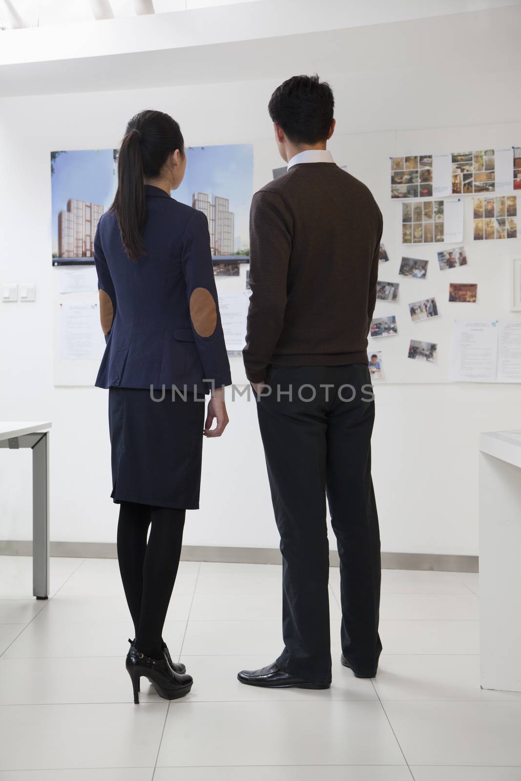 Coworkers looking at the wall in the office