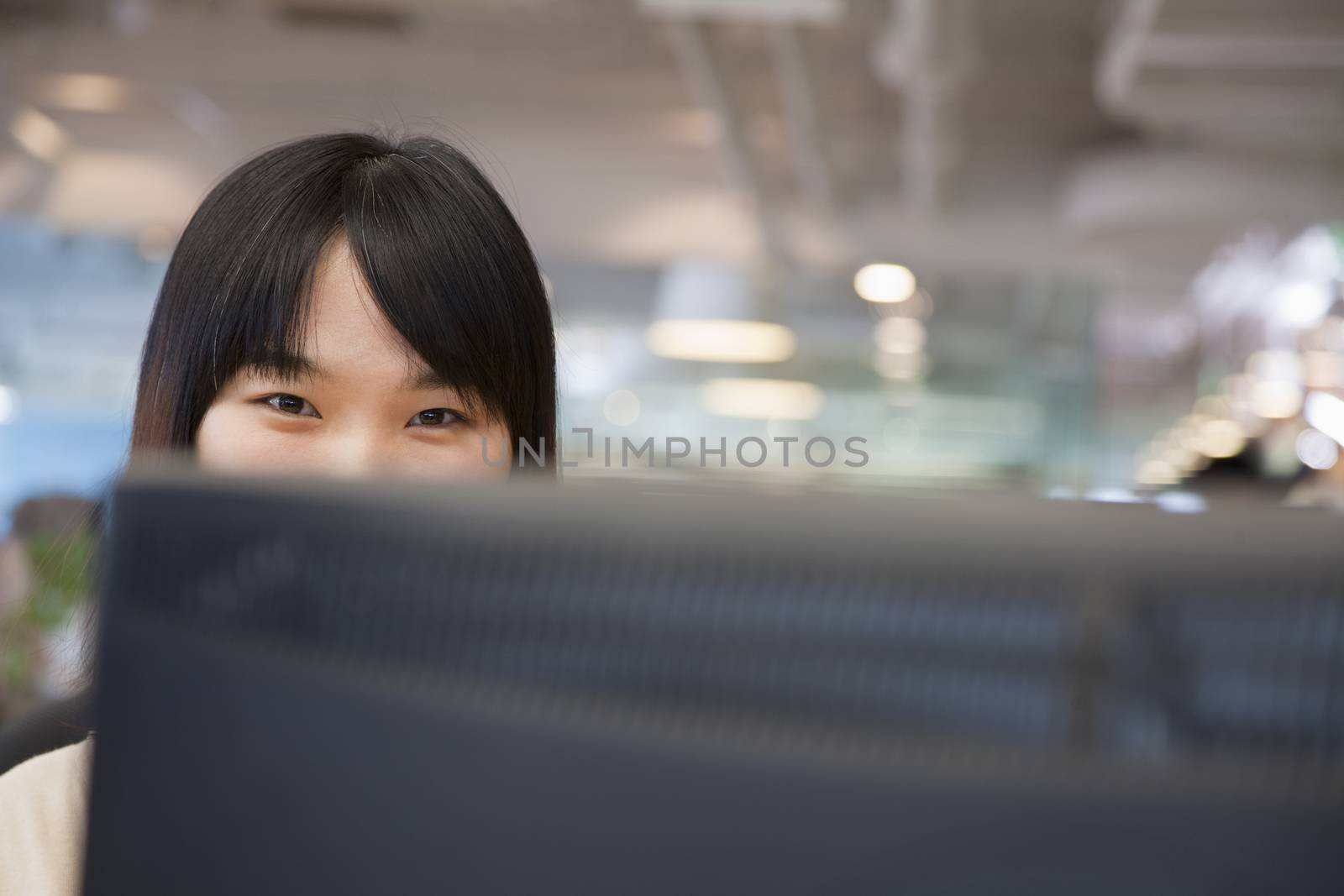 Young Businesswoman Looking over Computer in the Office