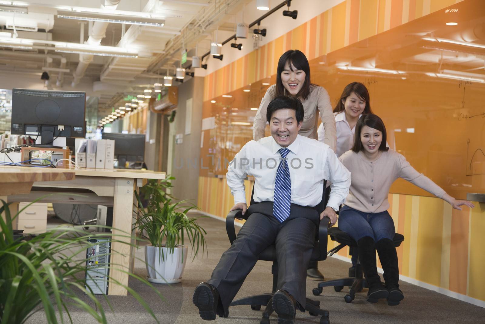 Businesswomen Pushing Her Colleagues in the Chair by XiXinXing