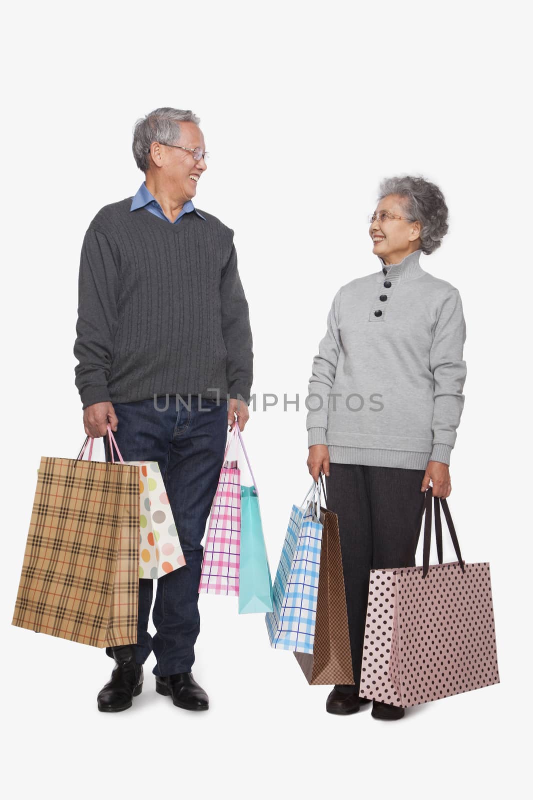 Senior couple with shopping bags by XiXinXing