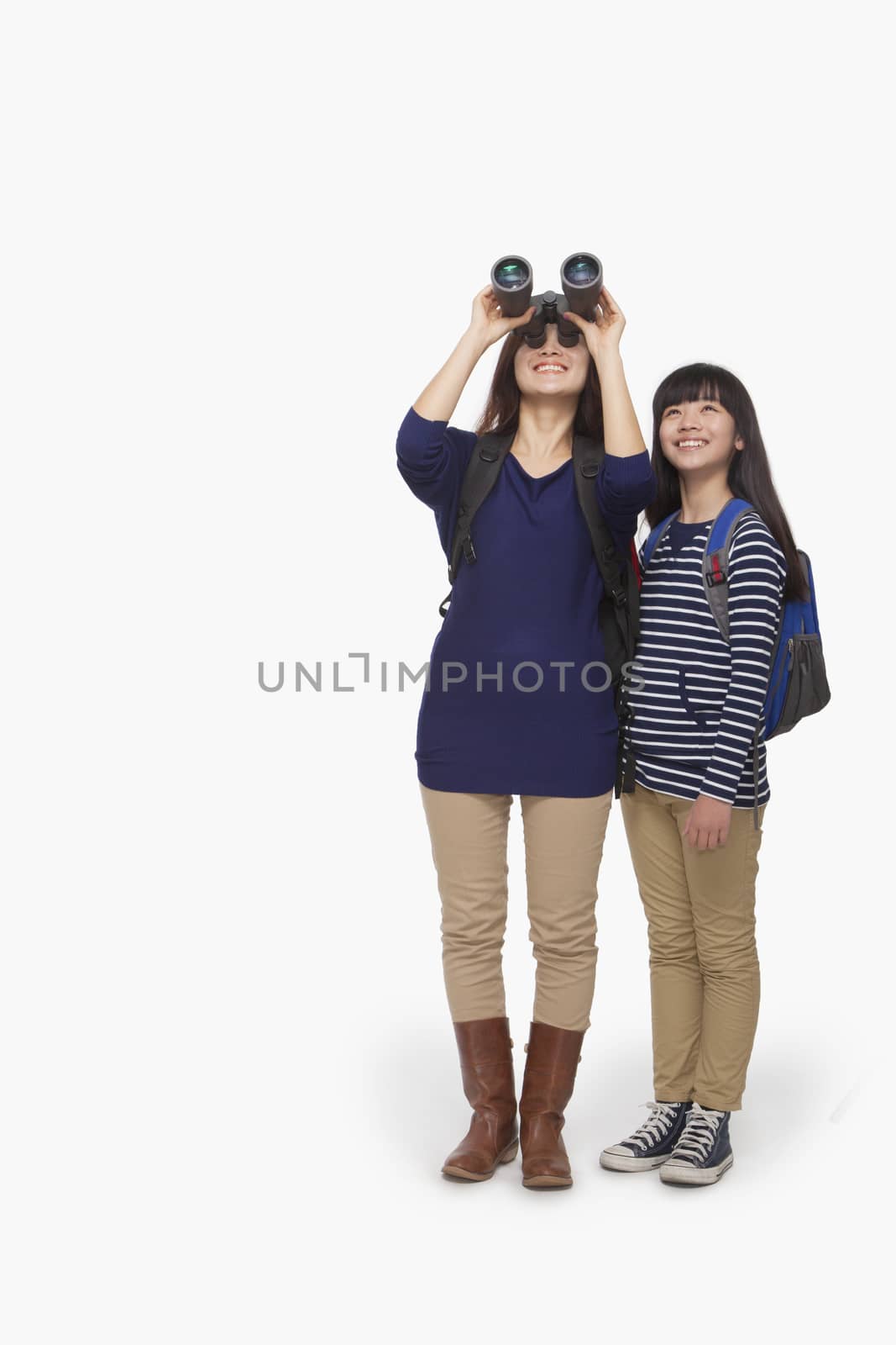 Mother looking through binoculars with daughter next to her