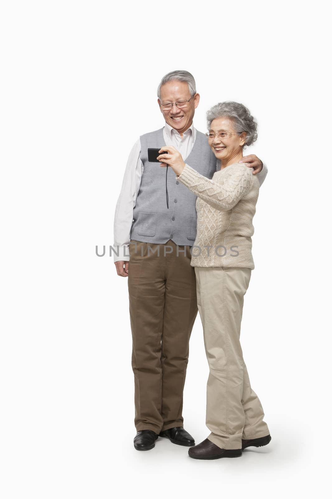 Senior couple taking picture with digital camera