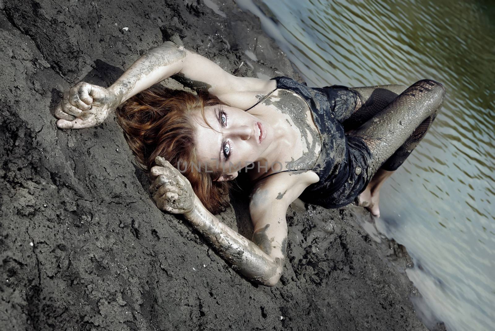 Dirty woman laying in the beach with passionate emotion