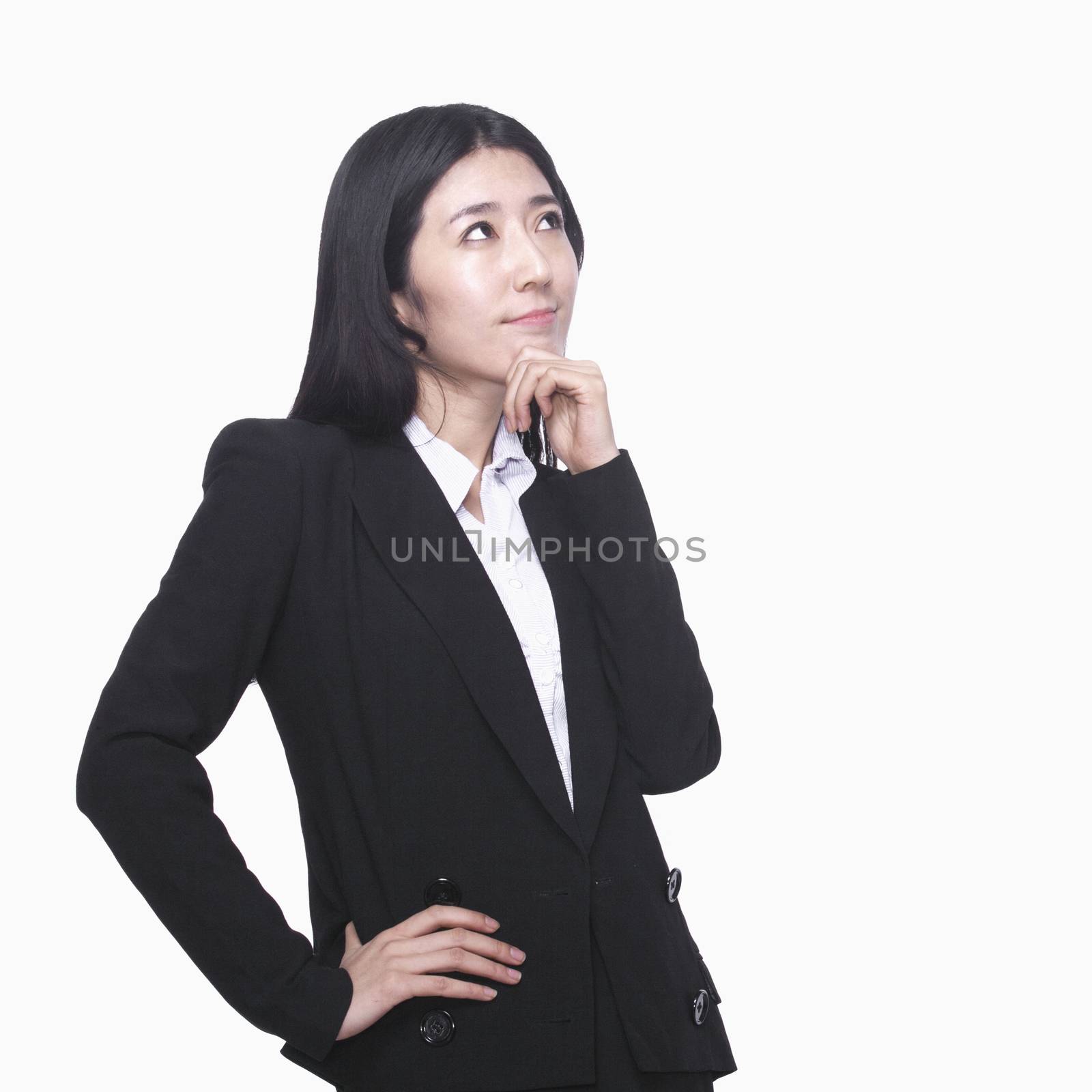 Businesswoman with hand on chin thinking by XiXinXing