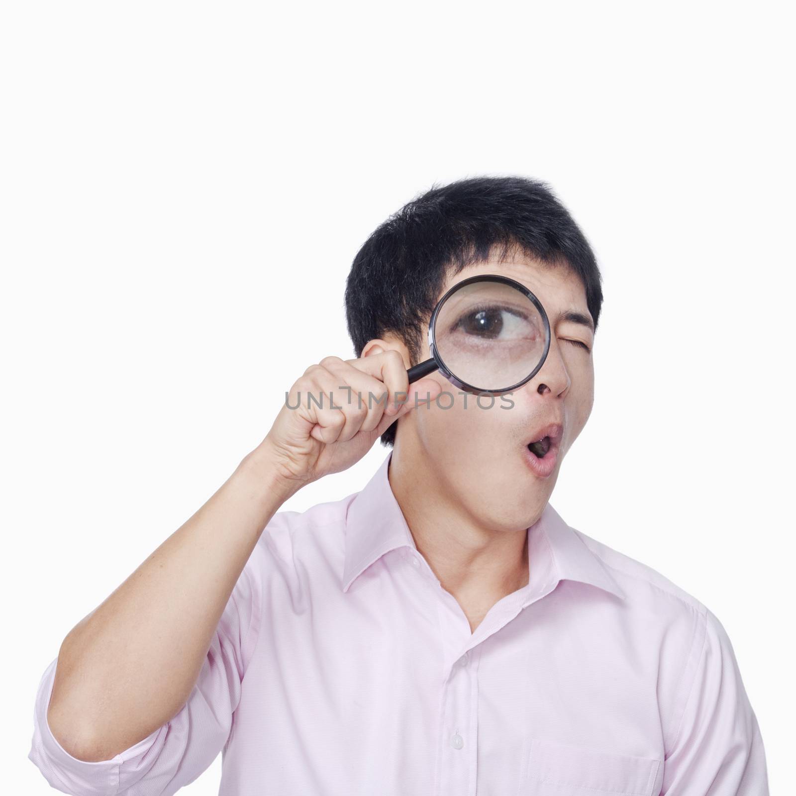 Young man looking through magnifying glass by XiXinXing
