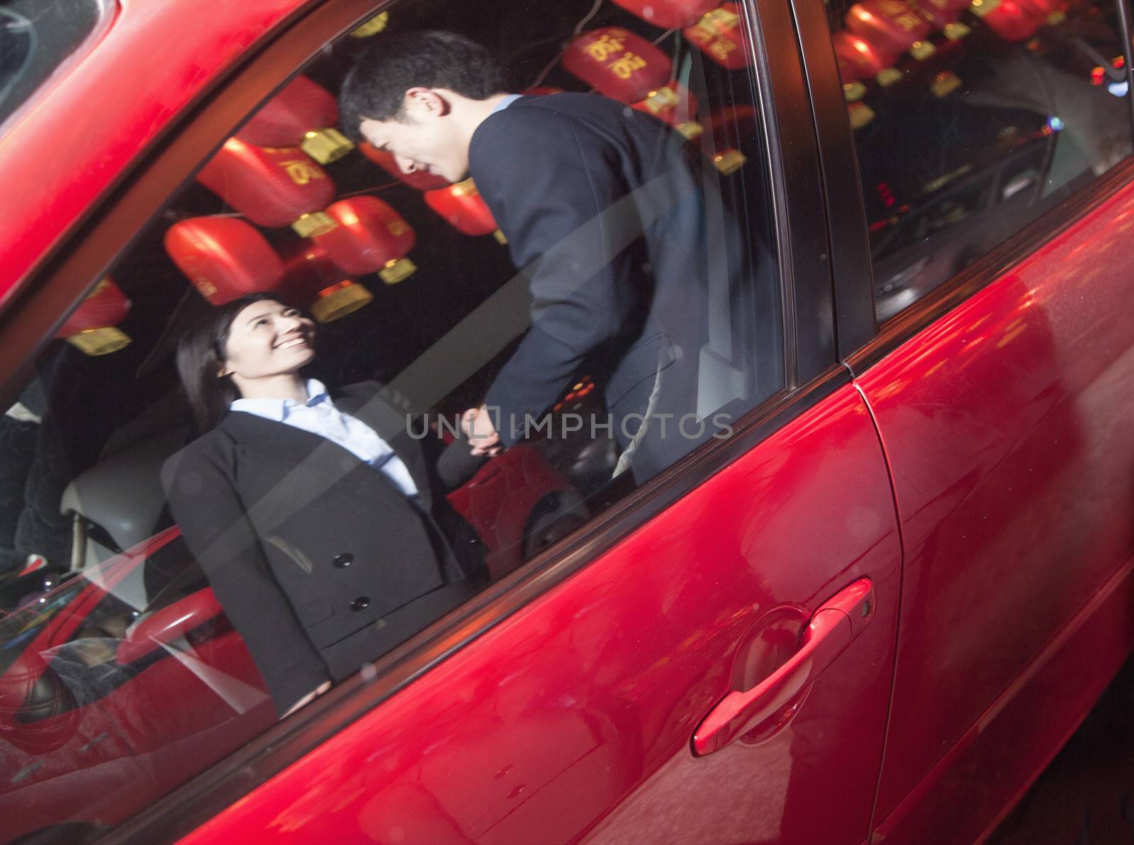 Coworkers handshaking next to the car at night, red lanterns on the background by XiXinXing