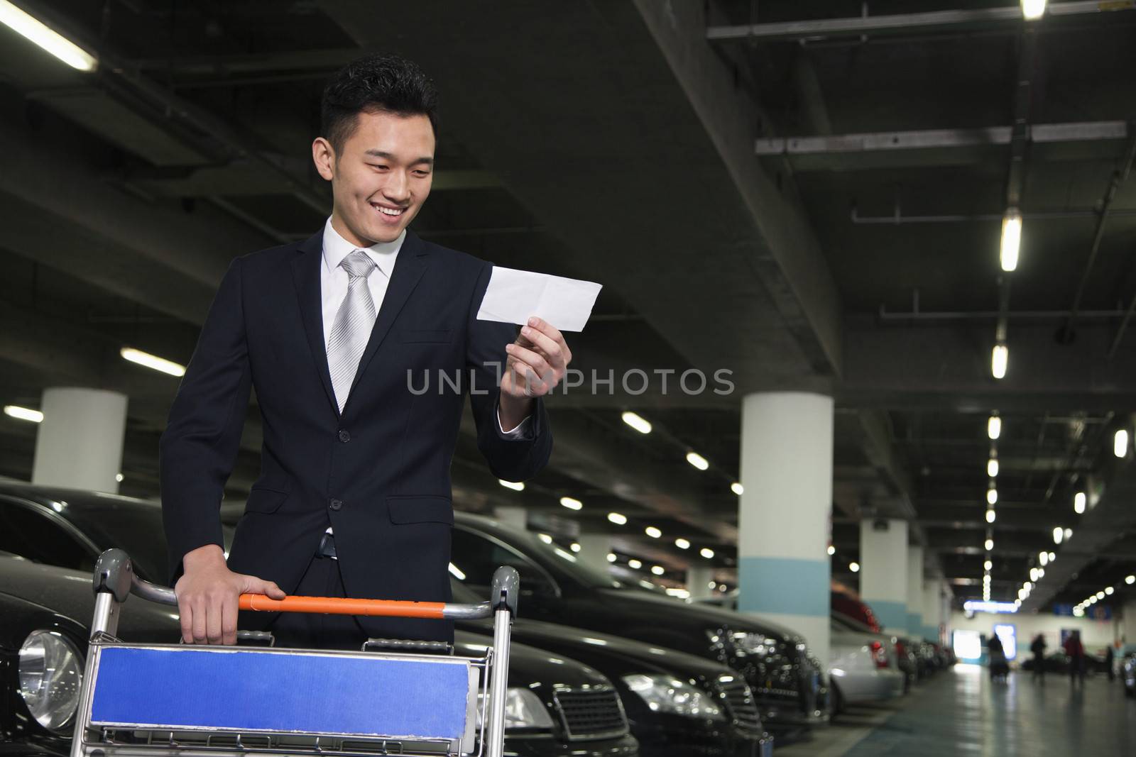 Traveler looking at ticket in airport parking lot