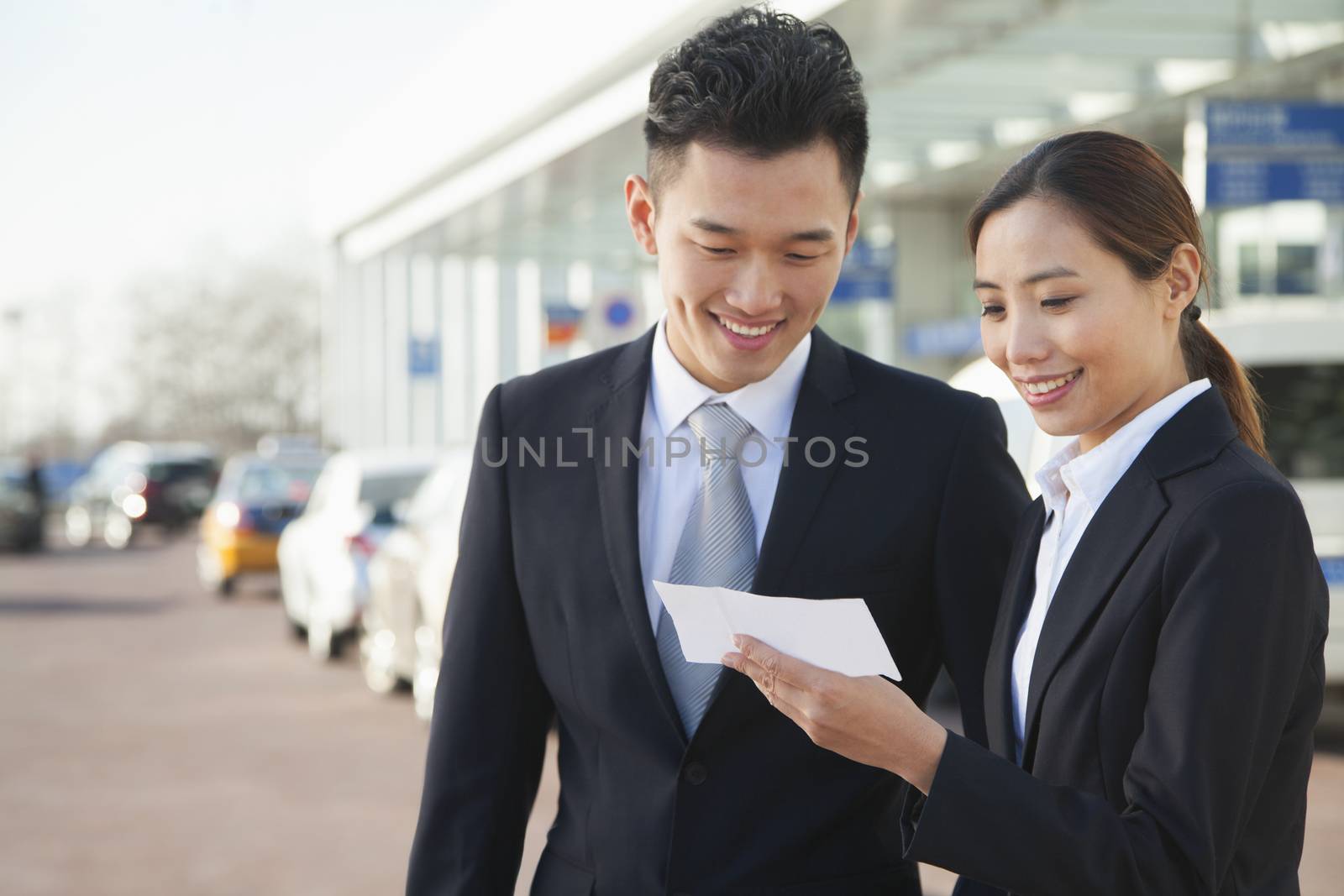 Two travelers looking at ticket in airport
