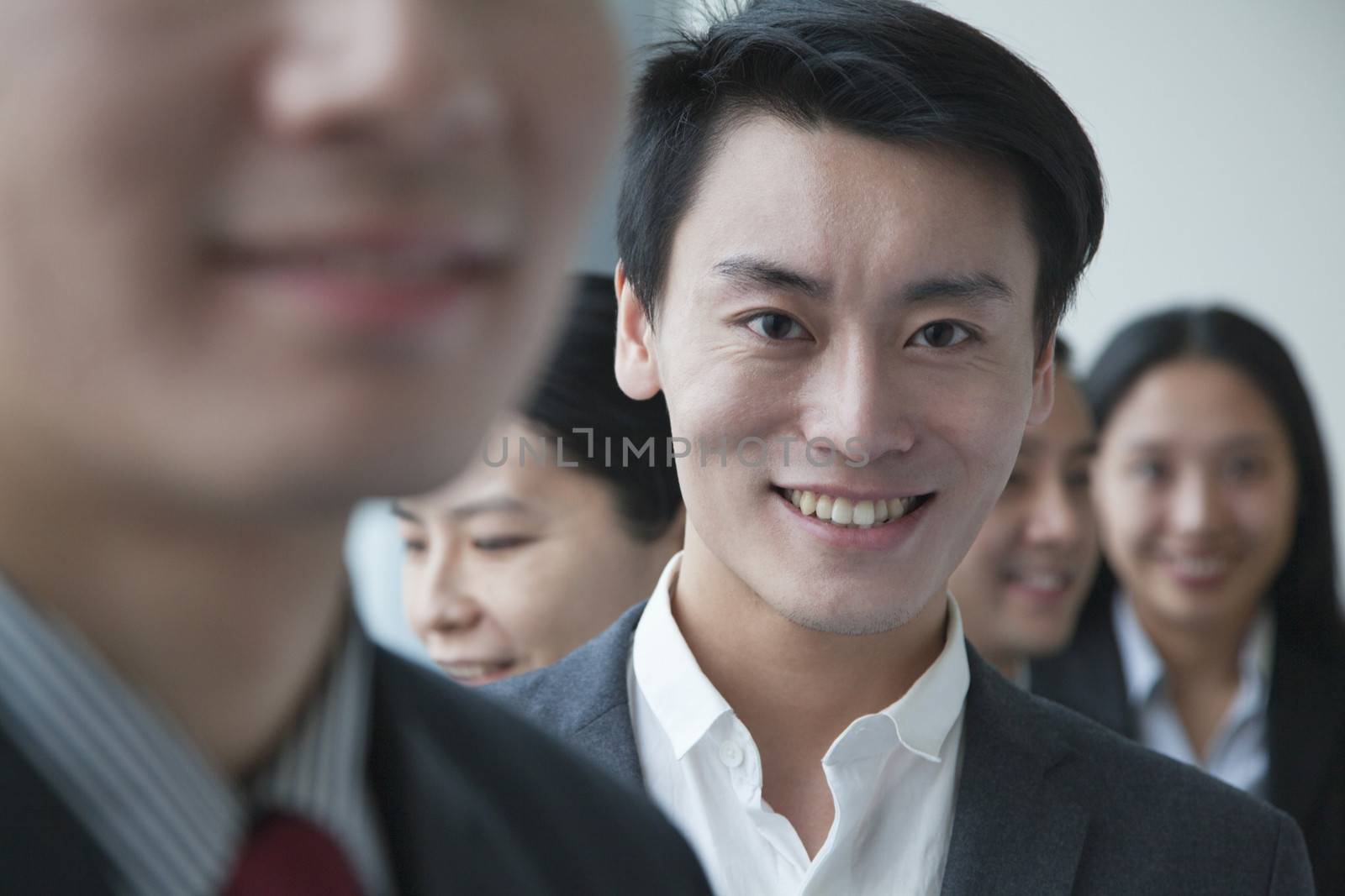 Businessman with co-workers in office portrait by XiXinXing