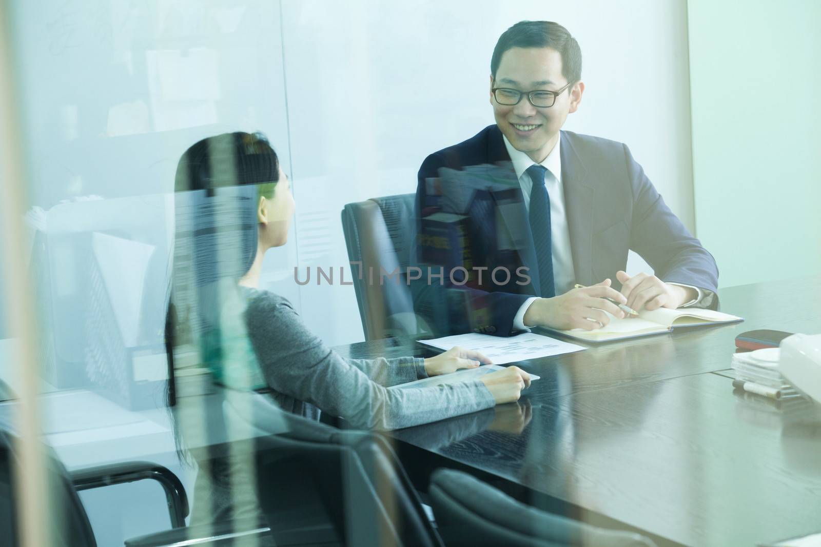 Colleagues Meeting in Conference Room, Shot Through Glass