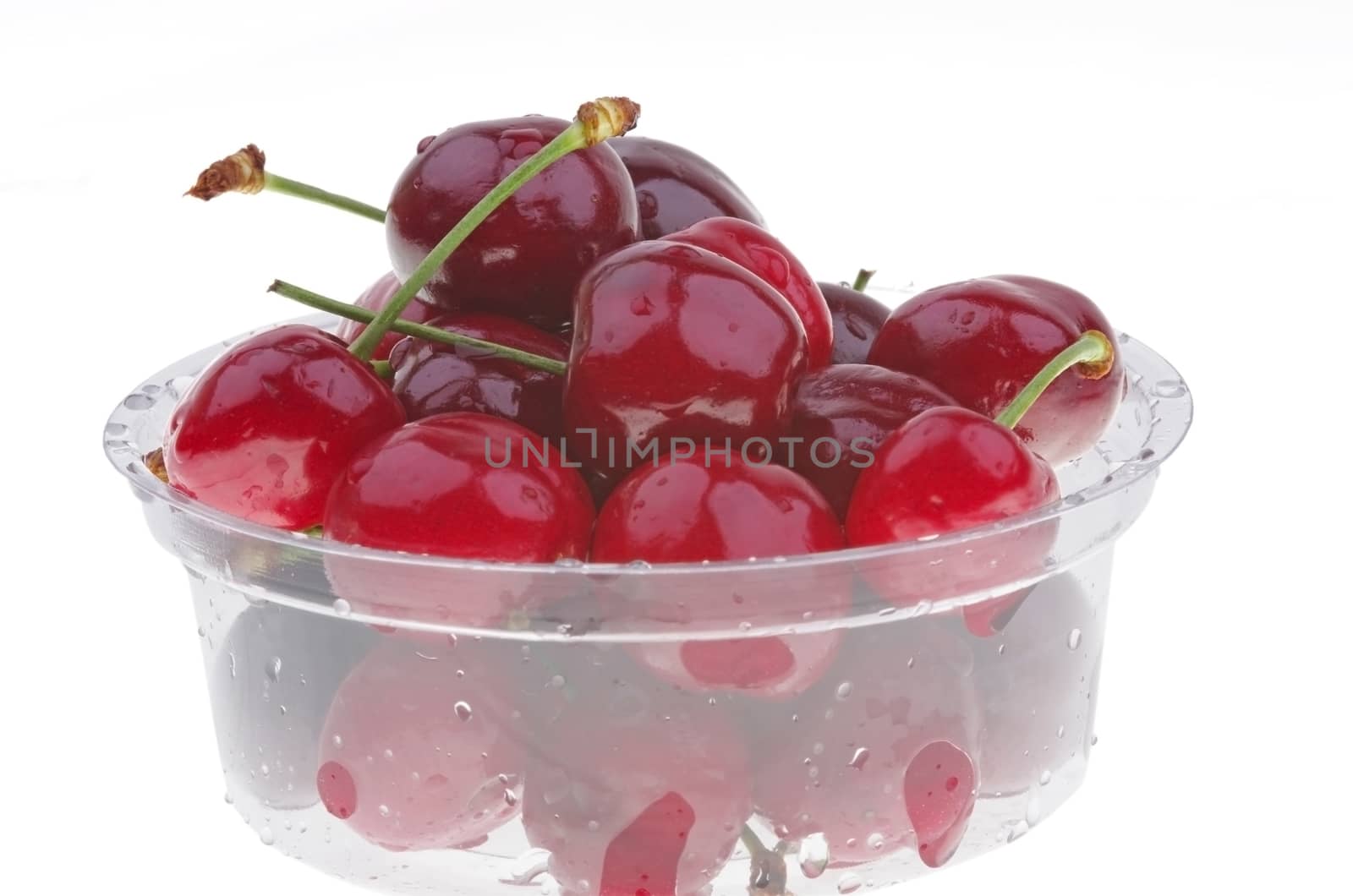 Fresh cherry in a plastic box, over white