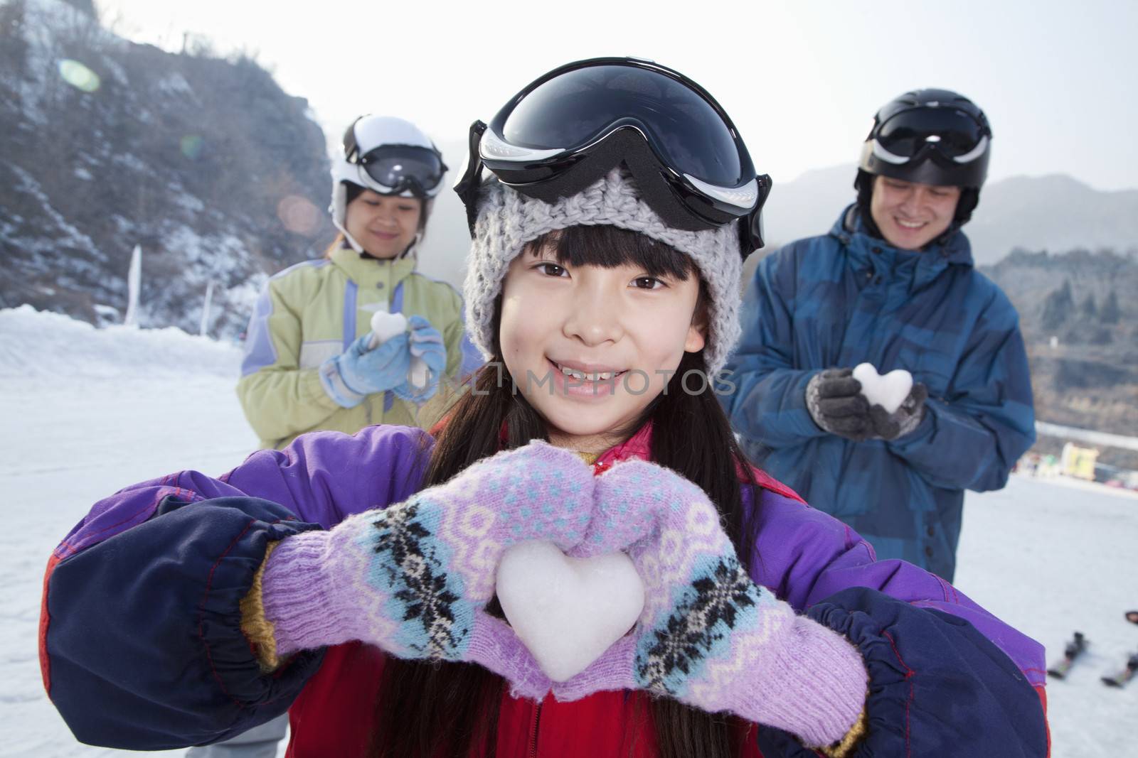 Family in Ski Resort, Daughter Showing Snow Heart by XiXinXing