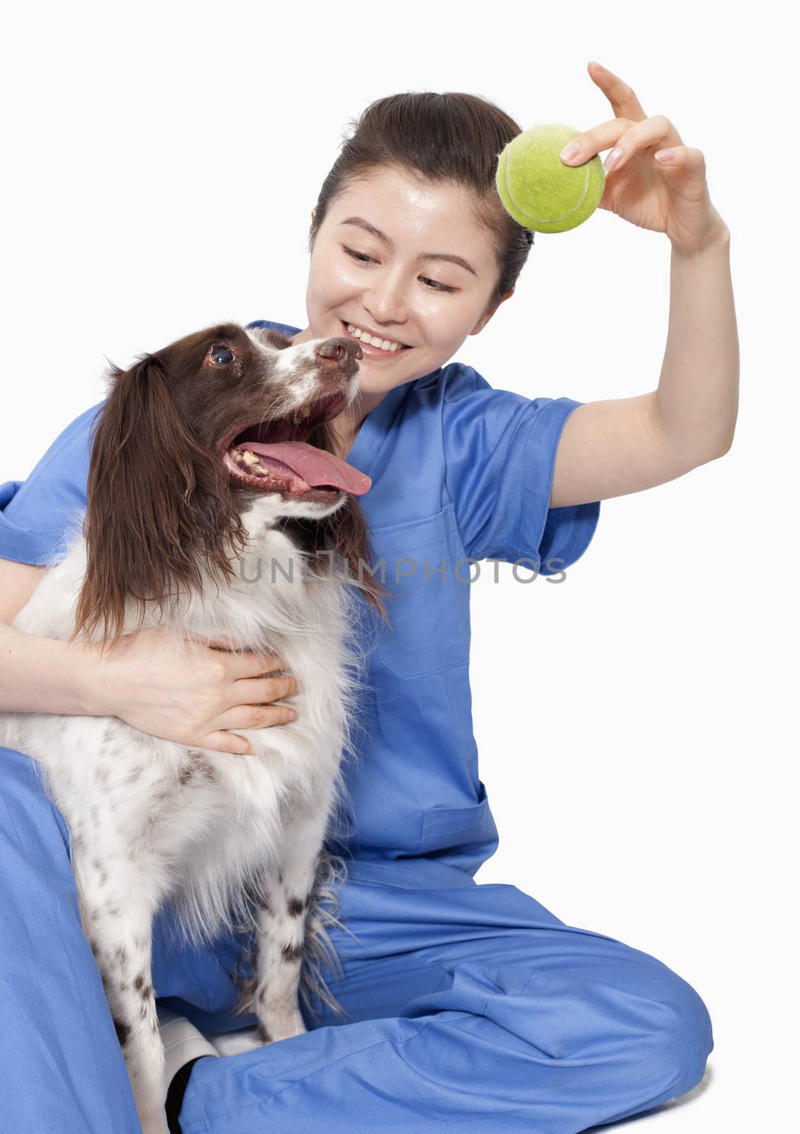 Portrait of female veterinarian holding a ball with a dog