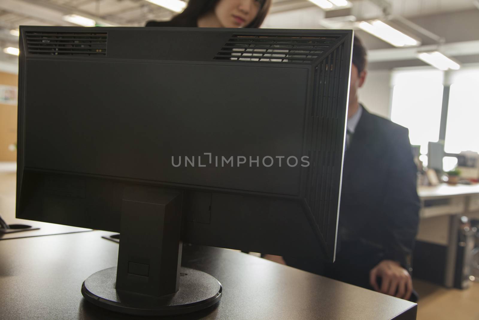 Two coworkers looking at computer monitor by XiXinXing
